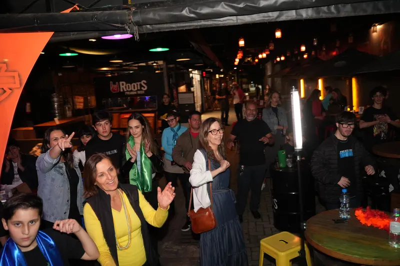 Público dançando em pé entre as mesas do pub